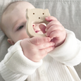 Baby holding wooden teether
